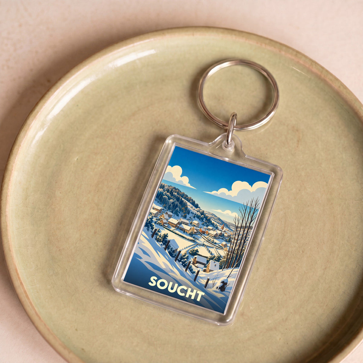 Porte-clés souvenir de la ville de Soucht avec une illustration hivernale stylisée.
