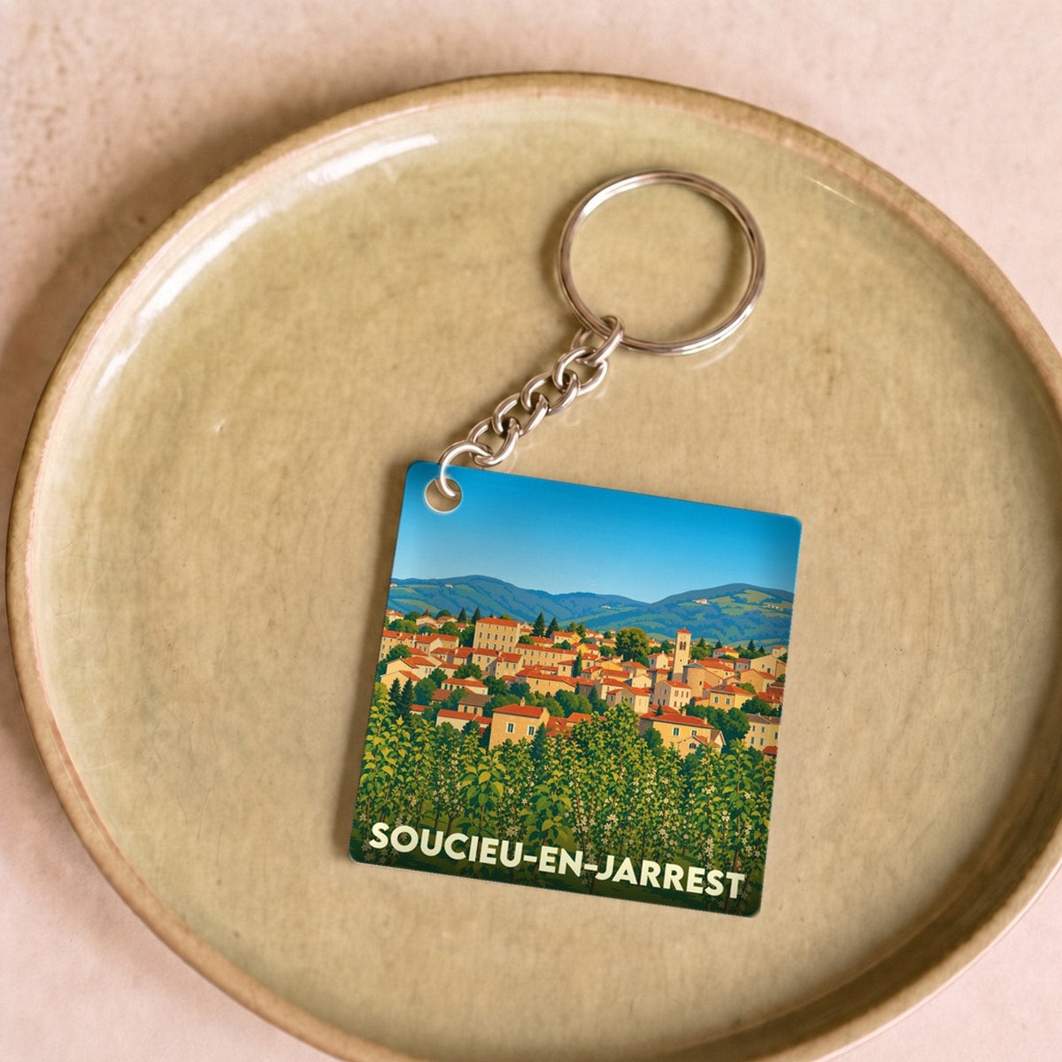 Porte-clés souvenir de la ville de Soucieu-en-Jarrest avec une illustration stylisée.
