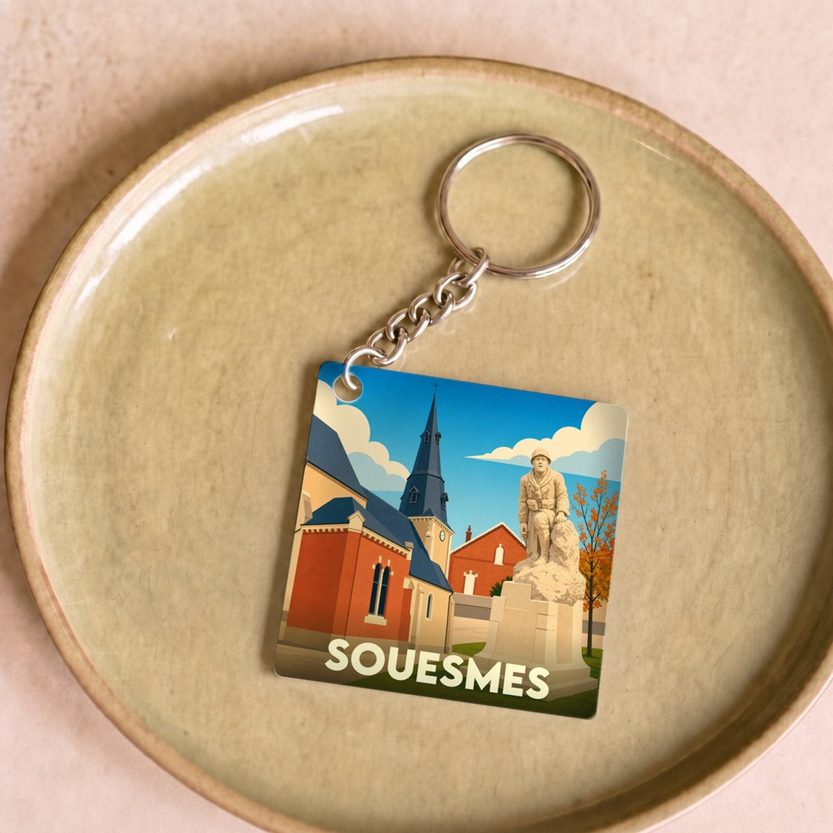 Porte-clés souvenir de la ville de Souesmes avec une illustration stylisée de son patrimoine.