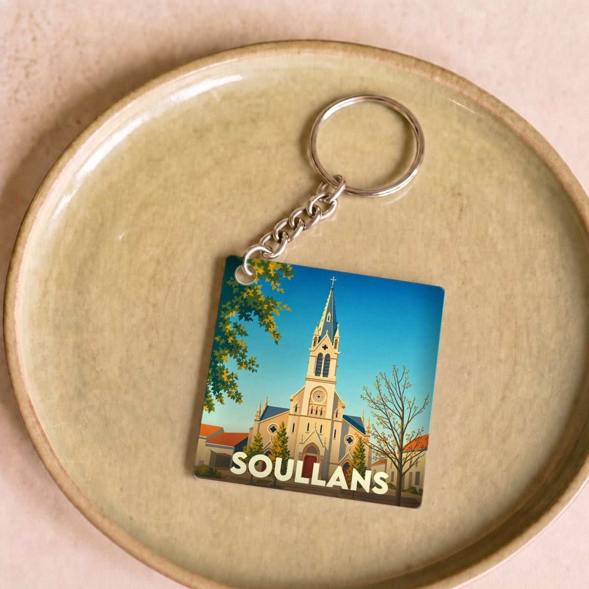 Porte-clés souvenir de la ville de Soullans avec une illustration stylisée de son église.