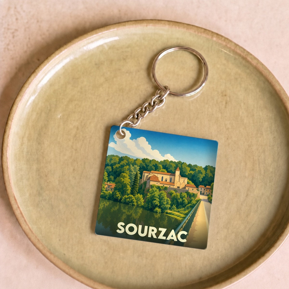 Porte-clés souvenir de la ville de Sourzac avec une illustration stylisée.