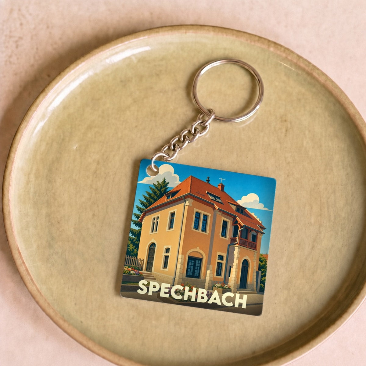 Porte-clés souvenir de la ville de Spechbach avec une illustration stylisée d'une maison traditionnelle.