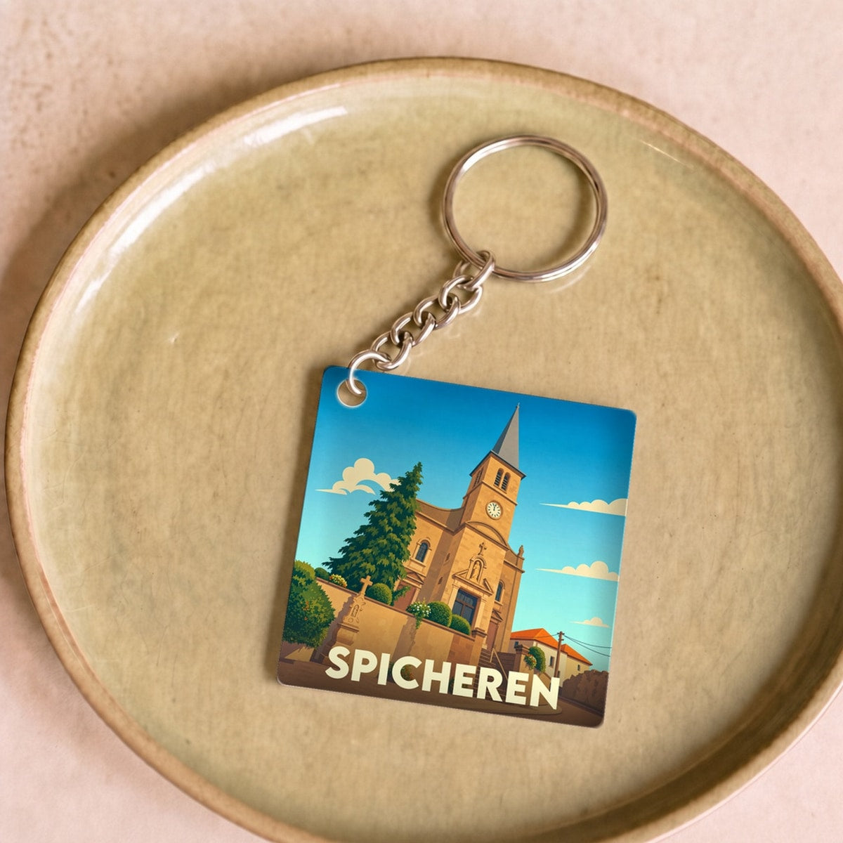 Porte-clés souvenir de la ville de Spicheren avec une illustration stylisée de son église.