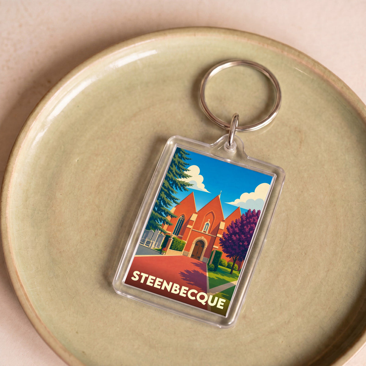 Porte-clés souvenir de la ville de Steenbecque avec une illustration stylisée de son église.