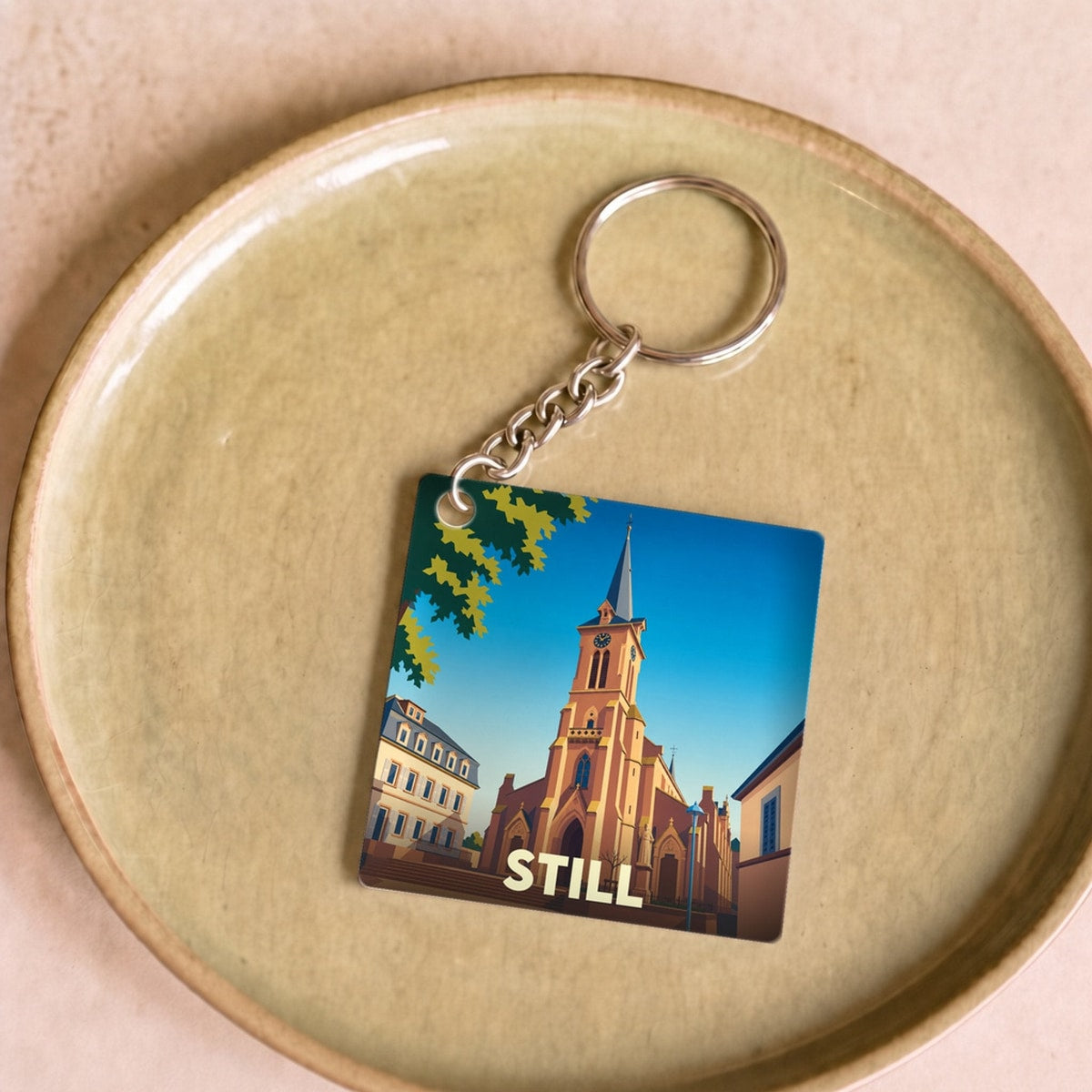 Porte-clés souvenir de la ville de Still avec une illustration stylisée de son église.