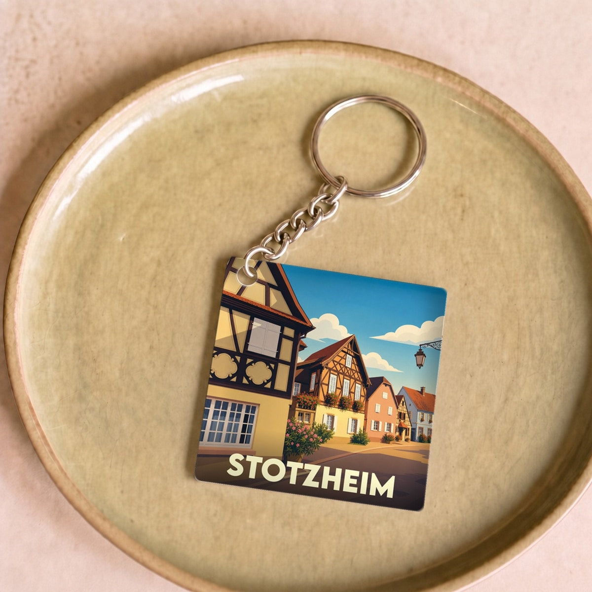 Porte-clés souvenir de la ville de Stotzheim avec une illustration stylisée de maisons à colombages.