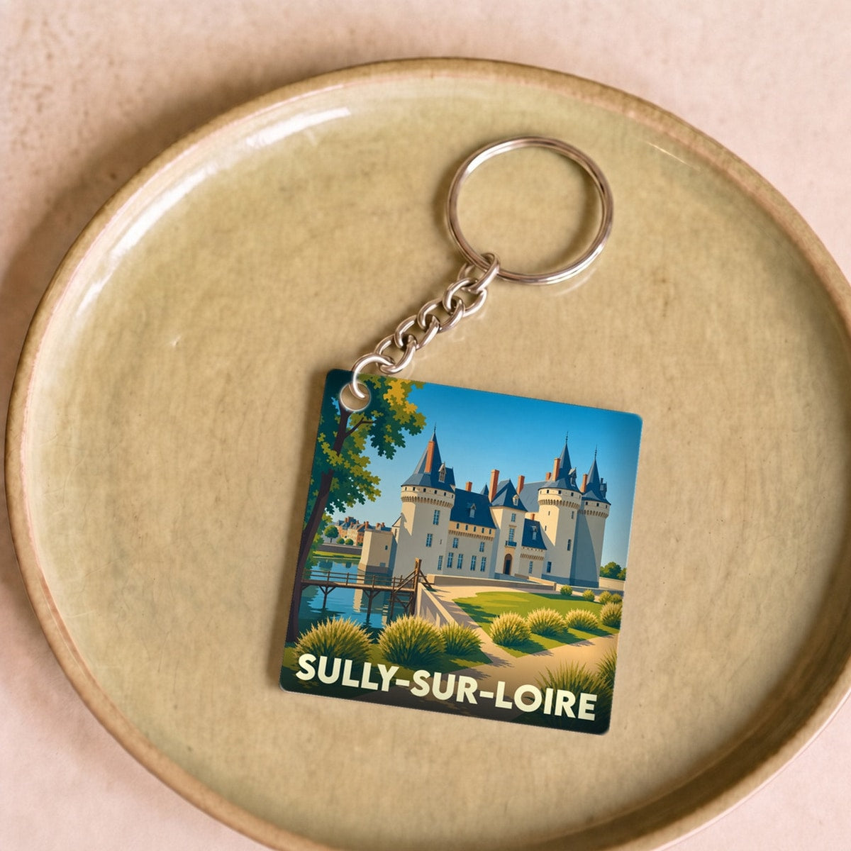 Porte-clés souvenir de la ville de Sully-sur-Loire avec une illustration stylisée de son château.
