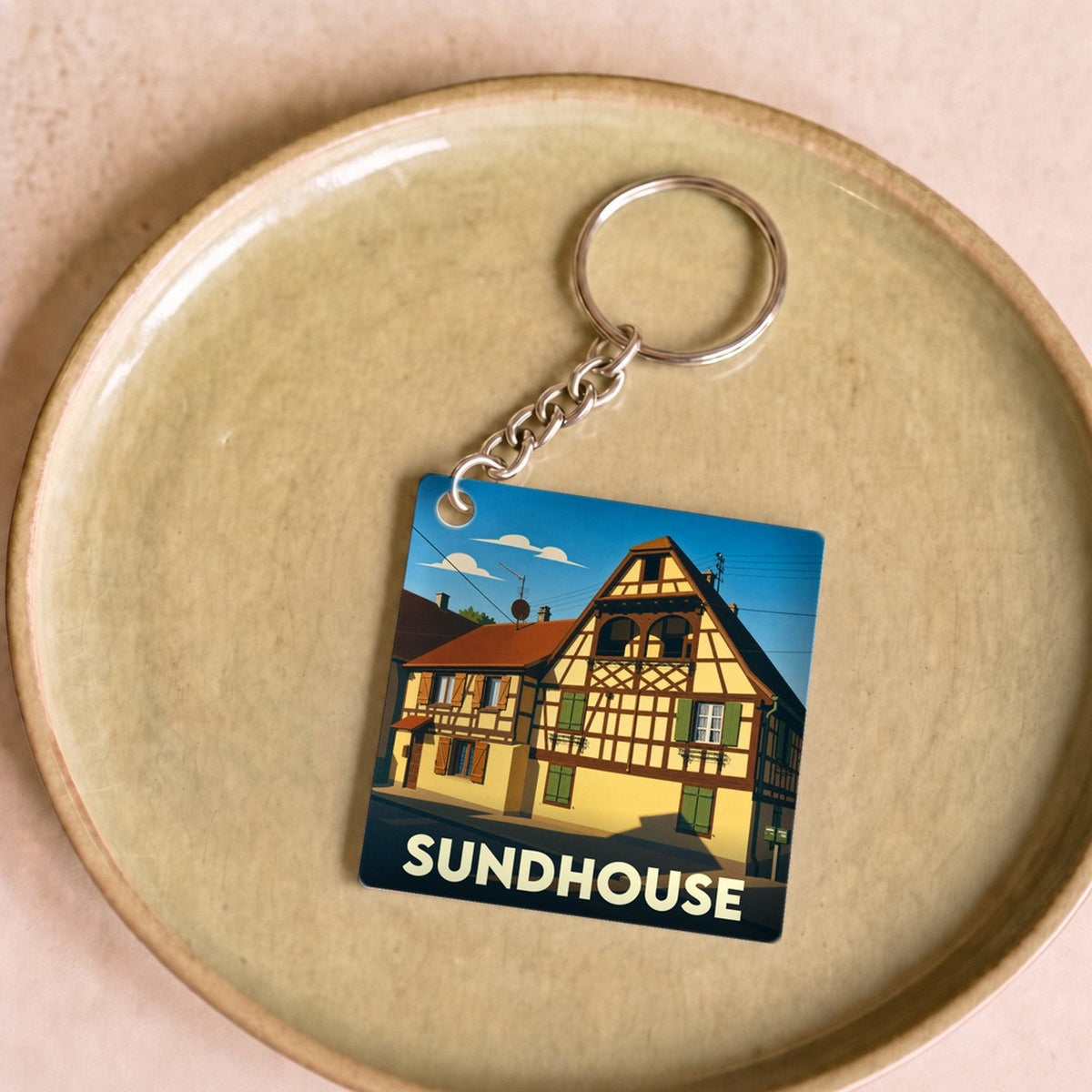 Porte-clés souvenir de la ville de Sundhouse avec une illustration stylisée d'une maison à colombages.