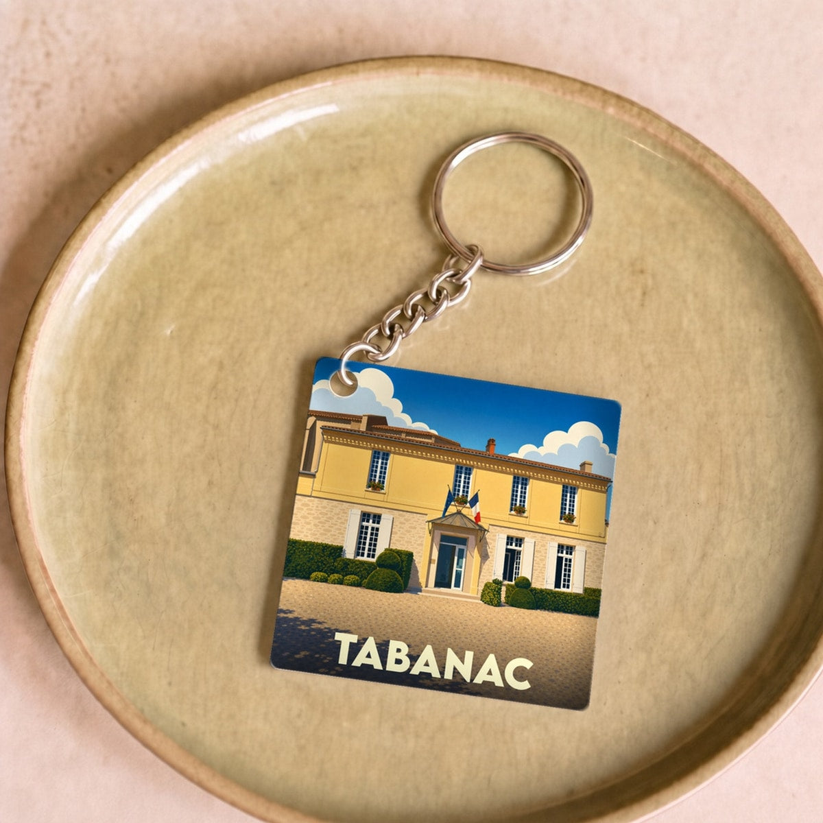 Porte-clés souvenir de la ville de Tabanac avec une illustration stylisée.