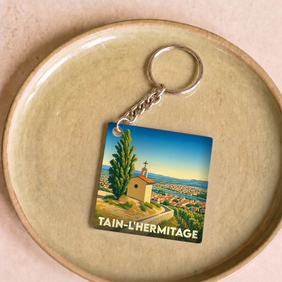 Porte-clés souvenir de la ville de Tain-l'Hermitage avec une illustration stylisée de son vignoble.