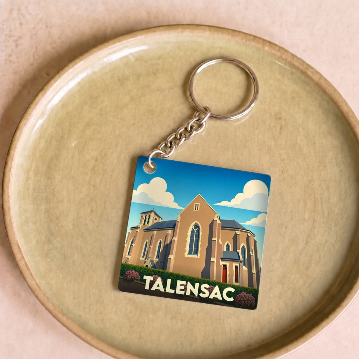 Porte-clés souvenir de la ville de Talensac avec une illustration stylisée de son église.