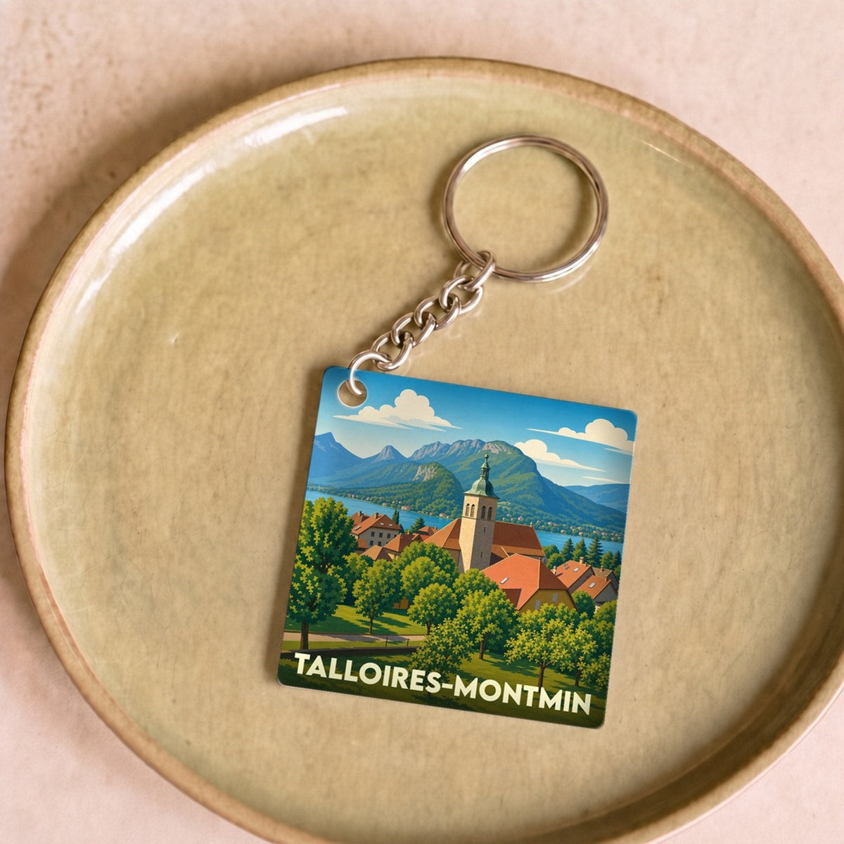 Porte-clés souvenir de la ville de Talloires-Montmin avec une illustration stylisée.