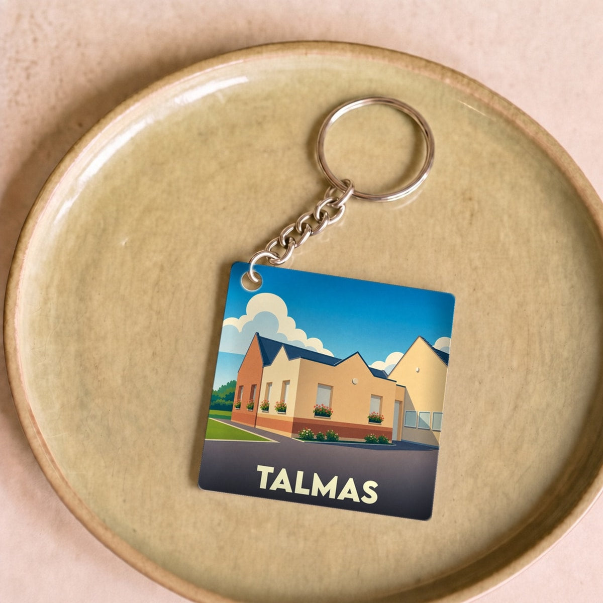 Porte-clés souvenir de la ville de Talmas avec une illustration stylisée.
