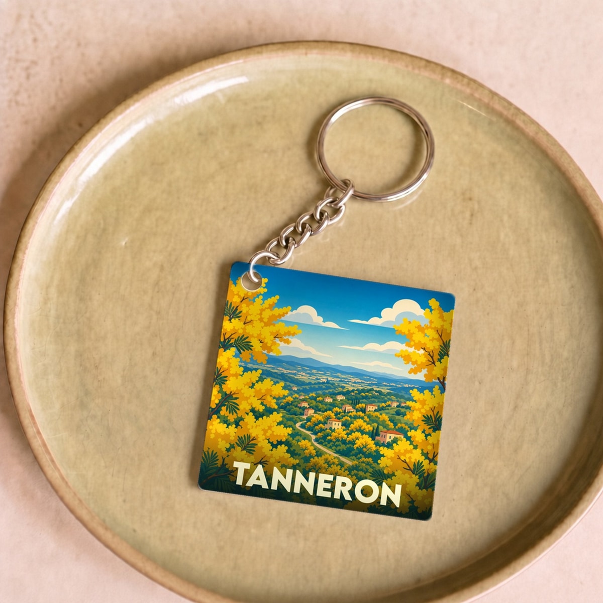 Porte-clés souvenir de la ville de Tanneron avec une illustration colorée de mimosas en fleurs.