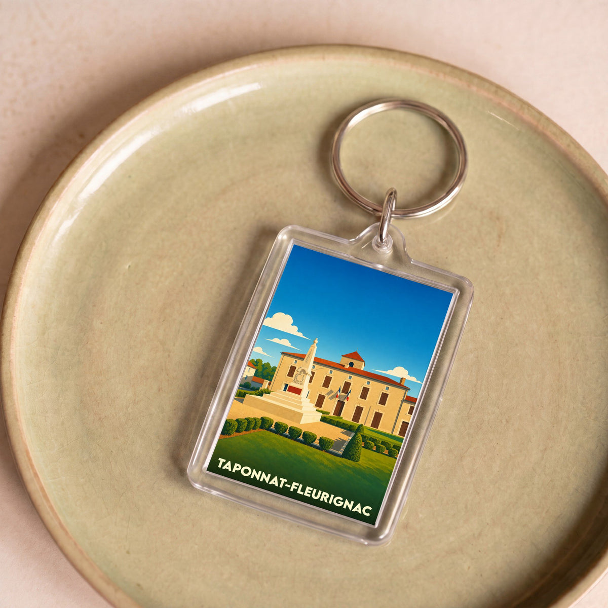 Porte-clés souvenir de la ville de Taponnat-Fleurignac avec une illustration stylisée.