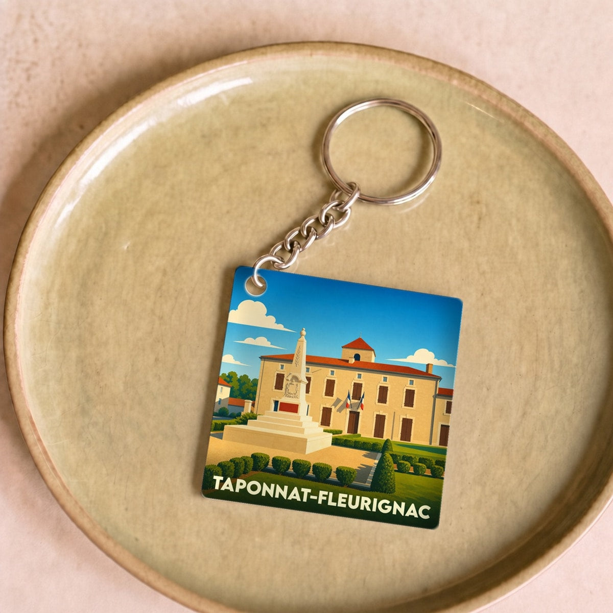 Porte-clés souvenir de la ville de Taponnat-Fleurignac avec une illustration stylisée.