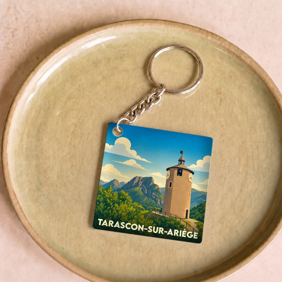 Porte-clés souvenir de Tarascon-sur-Ariège illustré d'un paysage de montagne et d'une tour historique.