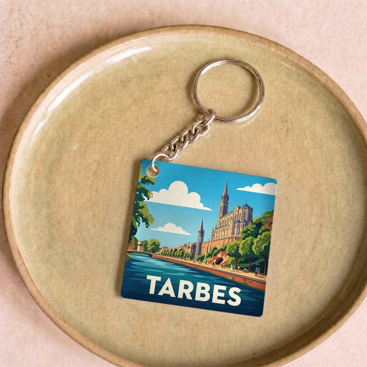 Porte-clés souvenir de la ville de Tarbes avec une illustration stylisée.