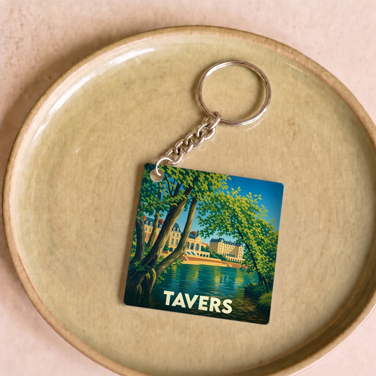 Porte-clés souvenir de la ville de Tavers avec une illustration stylisée d'un paysage de bord d'eau.