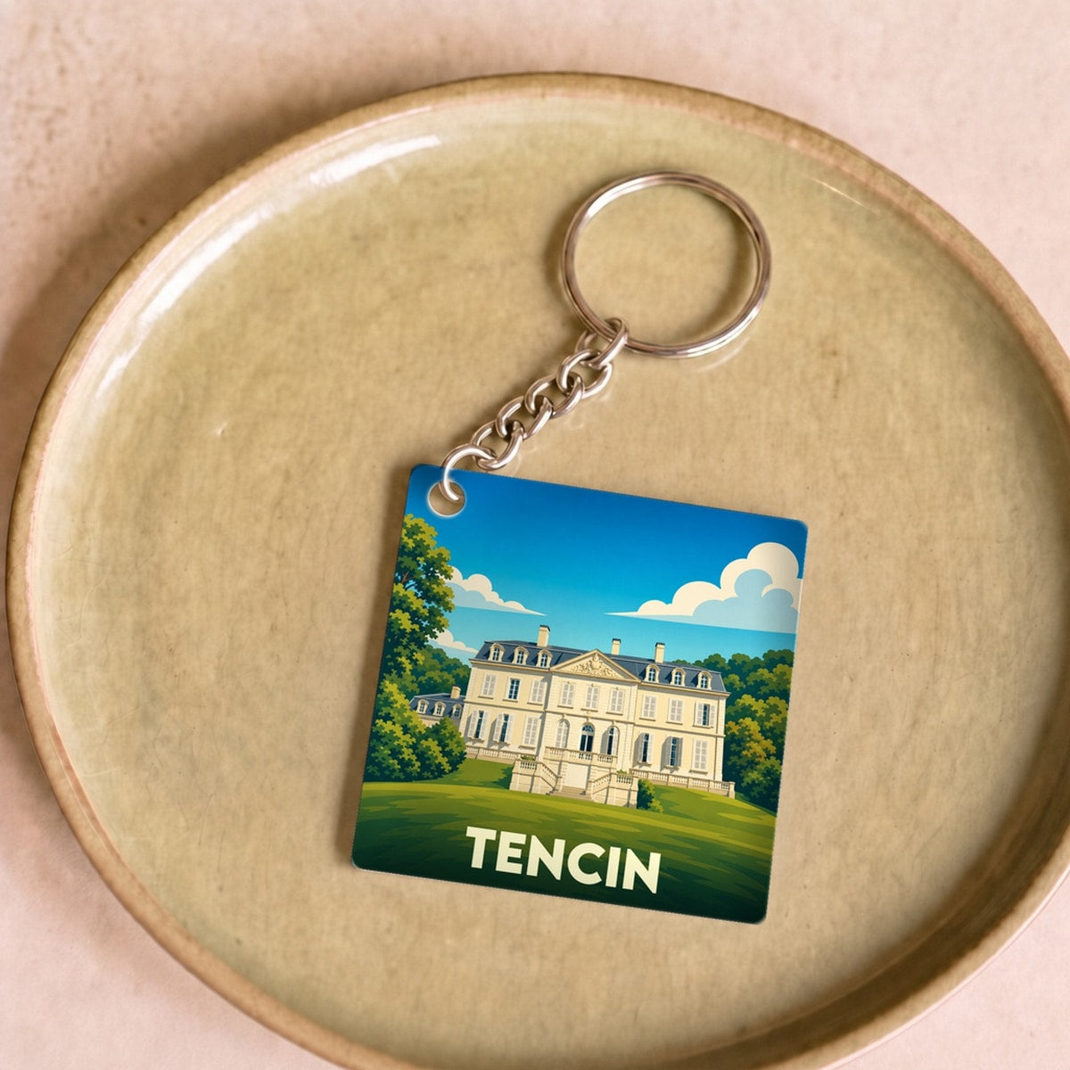 Porte-clés souvenir de la ville de Tencin avec une illustration stylisée de son château.
