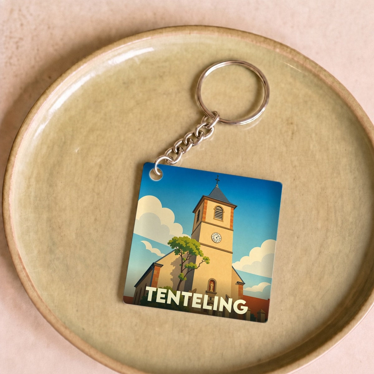 Porte-clés souvenir de la ville de Tenteling avec une illustration stylisée de son église.
