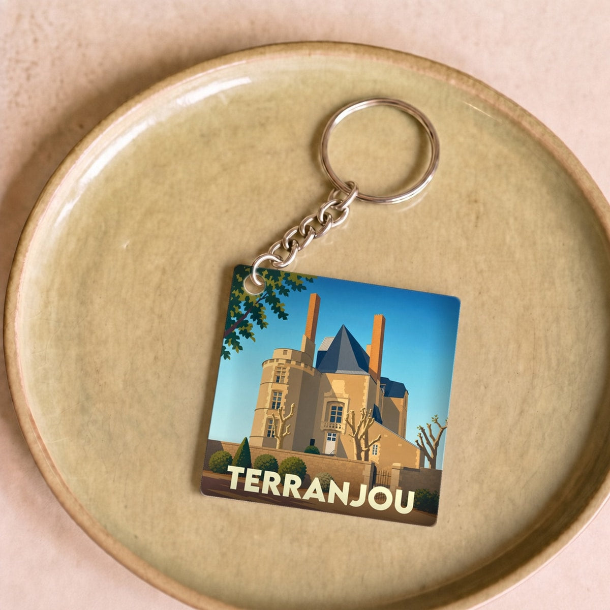 Porte-clés souvenir de la ville de Terranjou avec une illustration stylisée de son château.