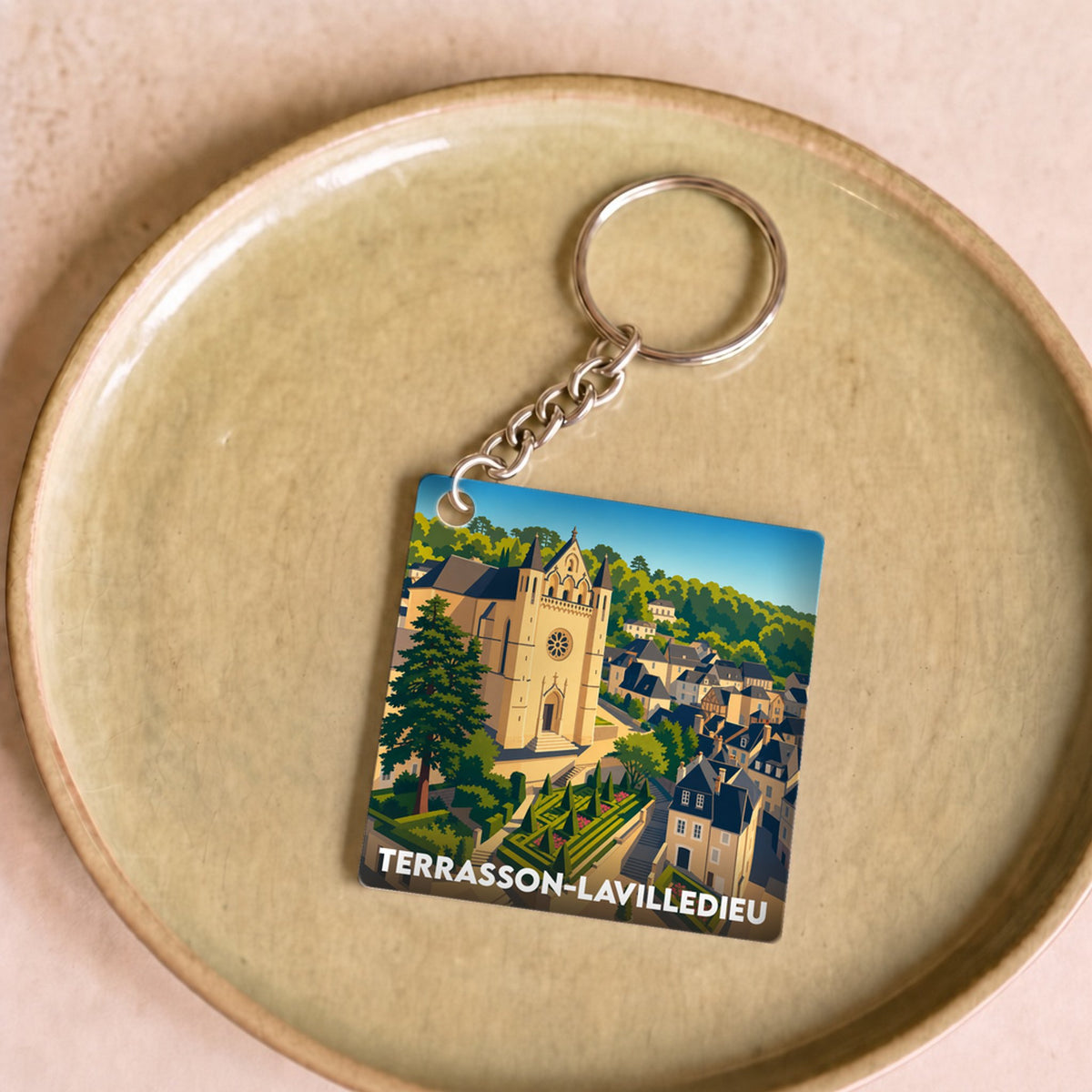 Porte-clés souvenir de la ville de Terrasson-Lavilledieu avec une illustration stylisée.