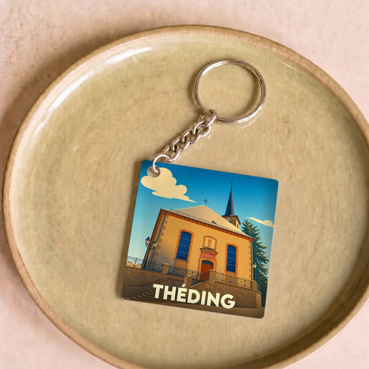 Porte-clés souvenir de la ville de Théding avec une illustration stylisée de son église.