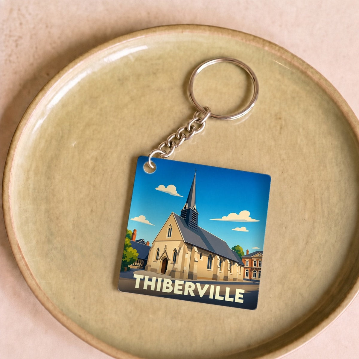 Porte-clés souvenir de la ville de Thiberville avec une illustration stylisée de son église.