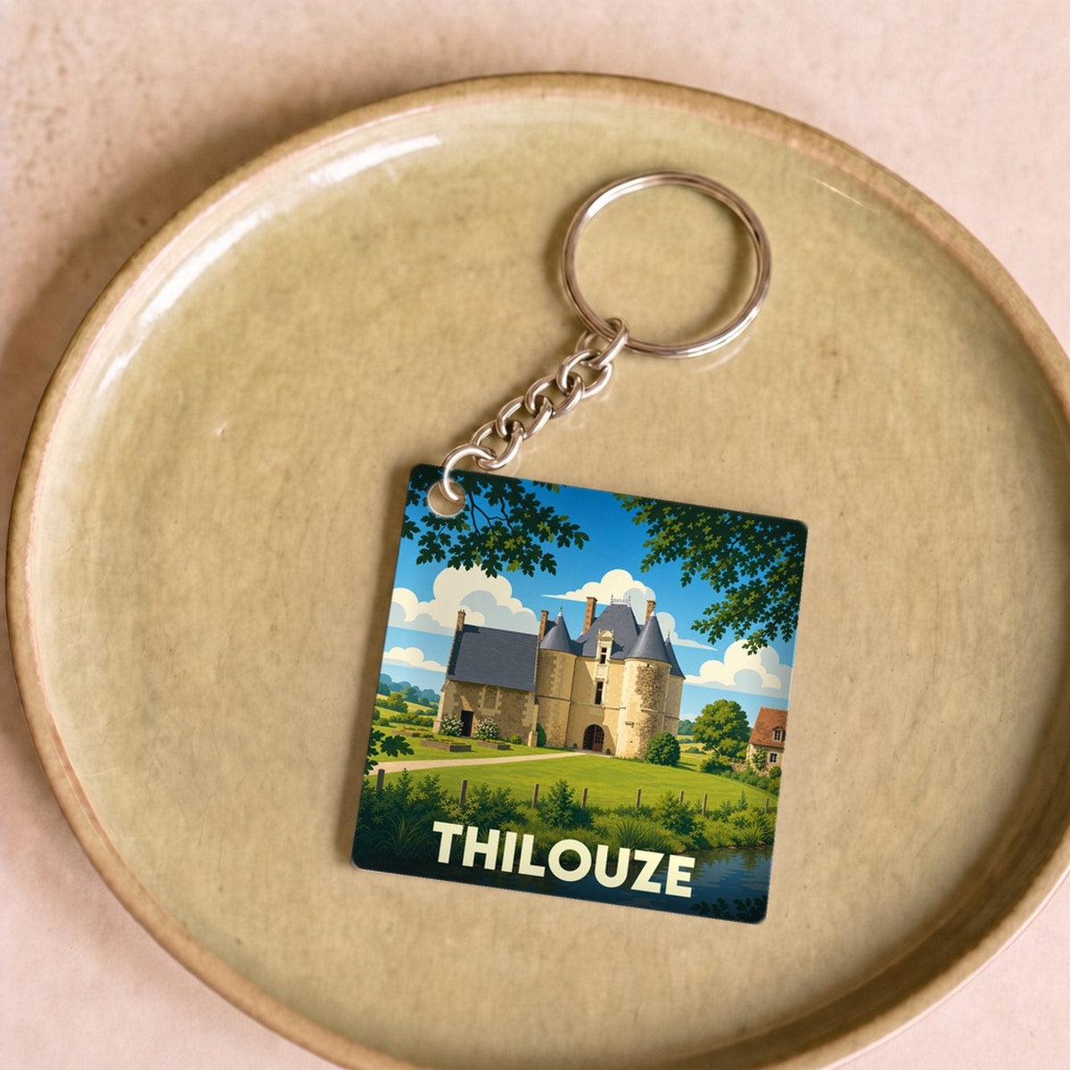 Porte-clés souvenir de la ville de Thilouze avec une illustration stylisée d'un château.