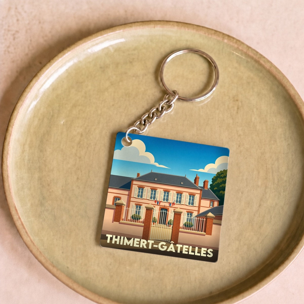 Porte-clés souvenir de la commune de Thimert-Gâtelles avec une illustration stylisée de sa mairie.
