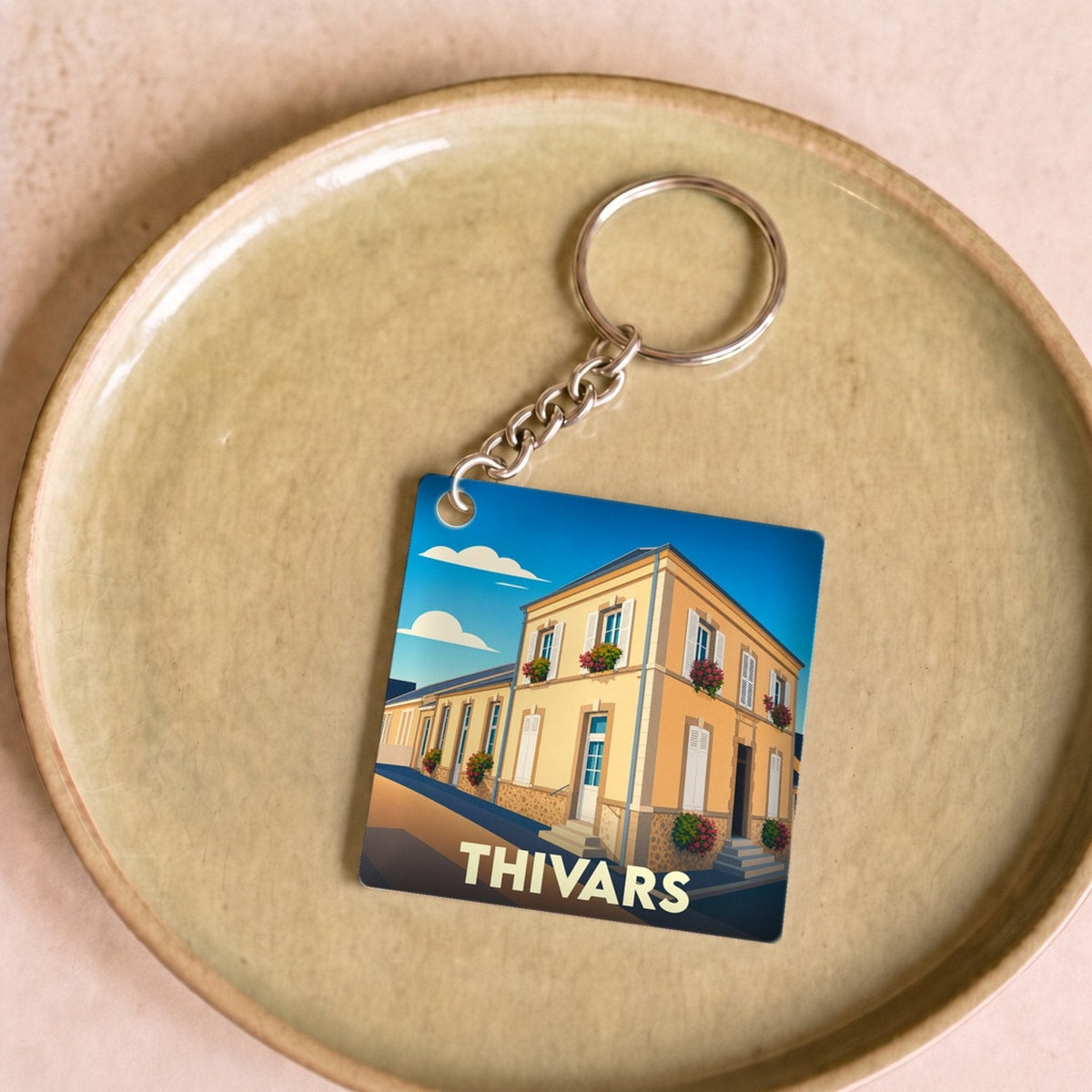 Porte-clés souvenir de la ville de Thivars avec une illustration stylisée.
