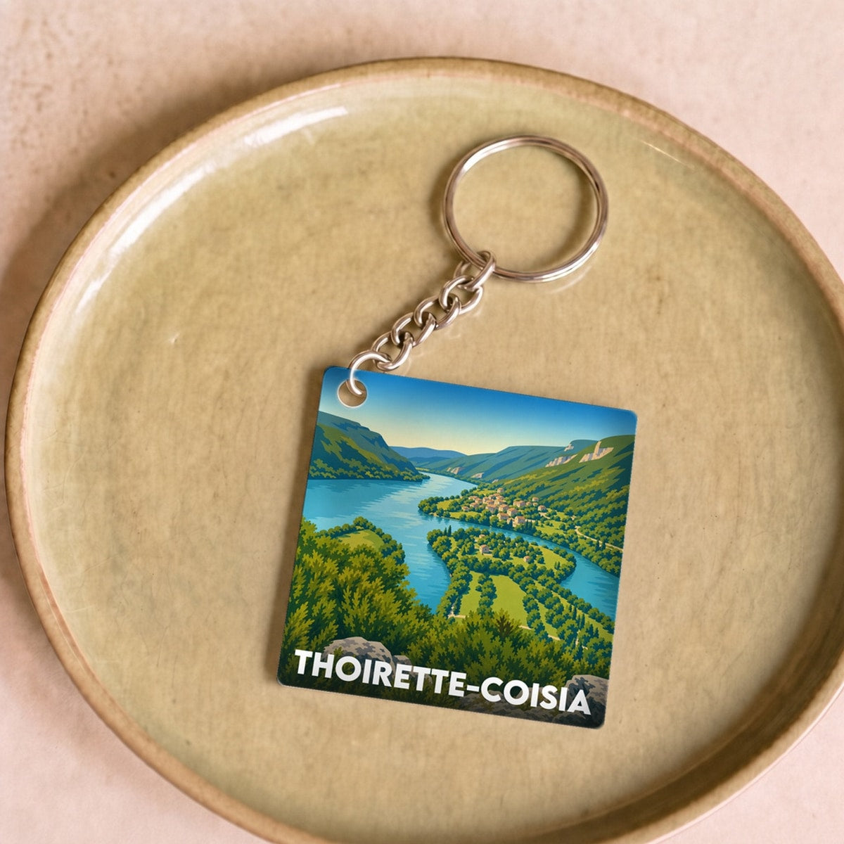 Porte-clés souvenir de la ville de Thoirette-Coisia avec une illustration stylisée.