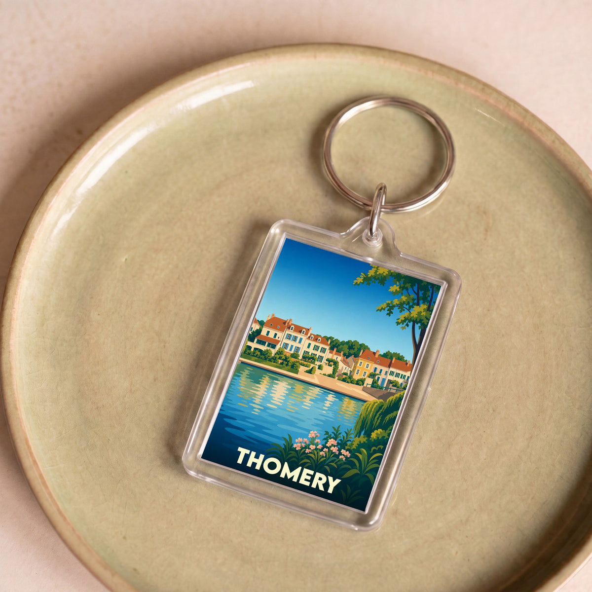 Porte-clés souvenir de la ville de Thomery avec une illustration stylisée des bords de Seine.