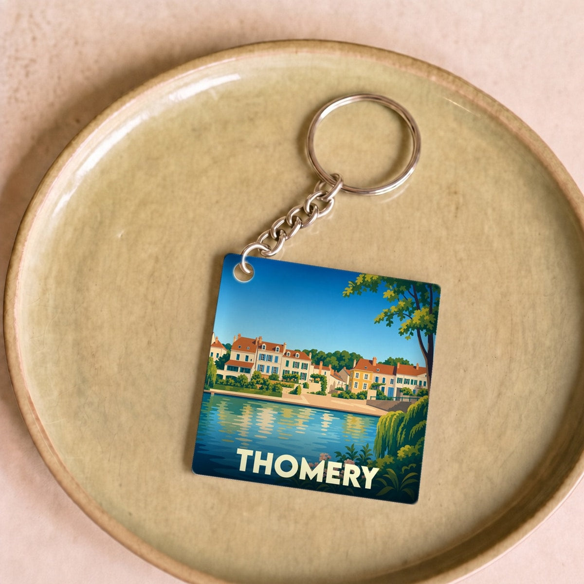 Porte-clés souvenir de la ville de Thomery avec une illustration stylisée des bords de Seine.