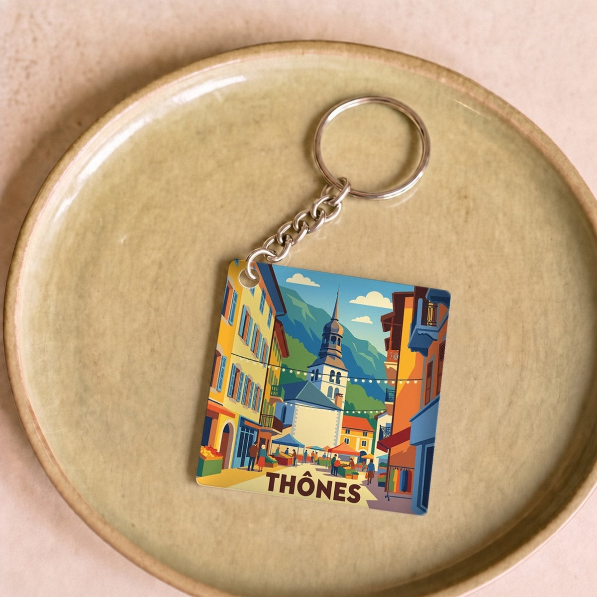 Porte-clés souvenir de la ville de Thônes avec une illustration stylisée.