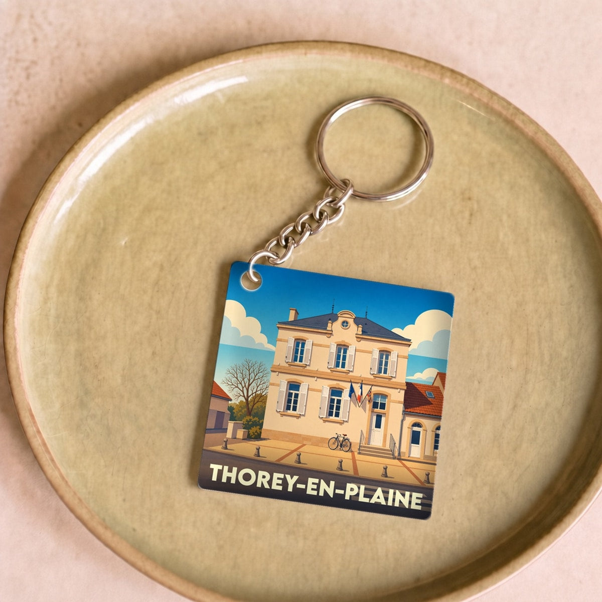Porte-clés souvenir de la ville de Thorey-en-Plaine avec une illustration stylisée.