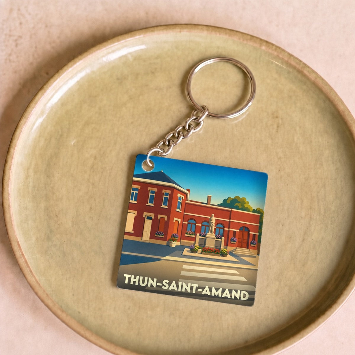 Porte-clés souvenir de la ville de Thun-Saint-Amand avec une illustration stylisée.