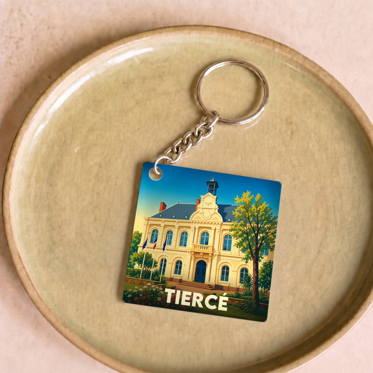 Porte-clés souvenir de la ville de Tiercé avec une illustration stylisée de son hôtel de ville.