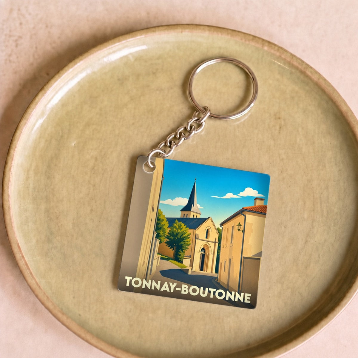 Porte-clés souvenir de la ville de Tonnay-Boutonne avec une illustration stylisée.