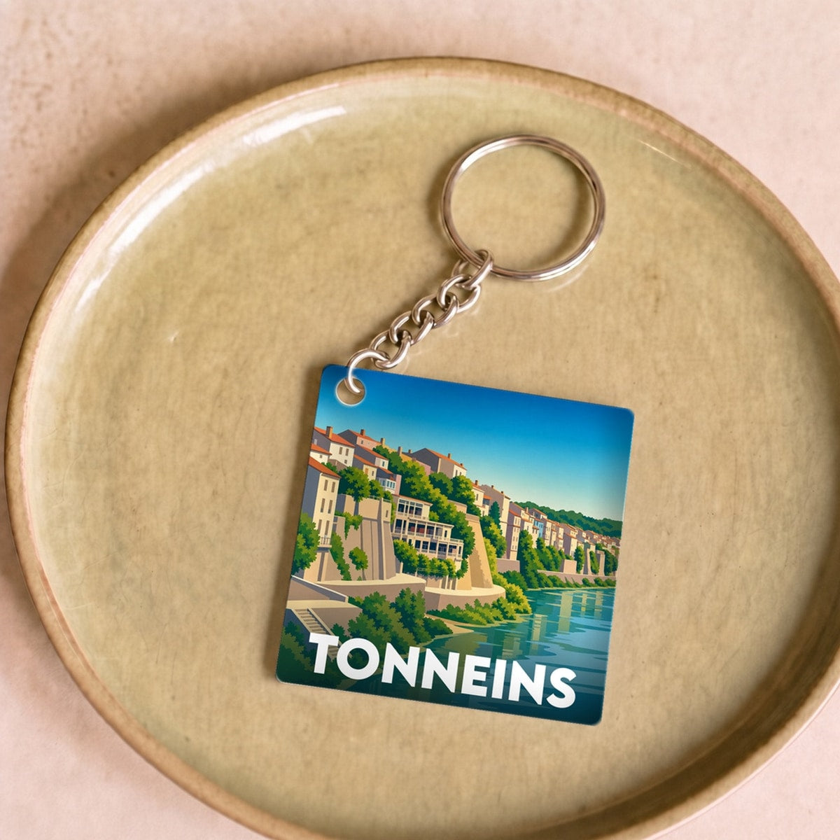 Porte-clés souvenir de la ville de Tonneins avec une illustration stylisée des quais.