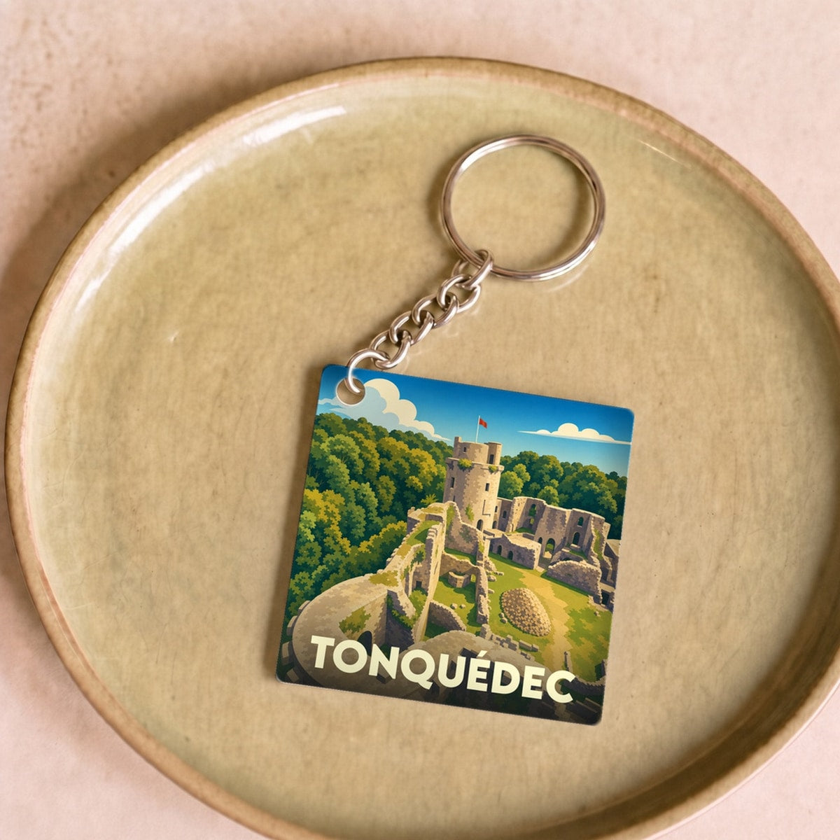 Porte-clés souvenir de la ville de Tonquédec avec une illustration stylisée de son château médiéval.