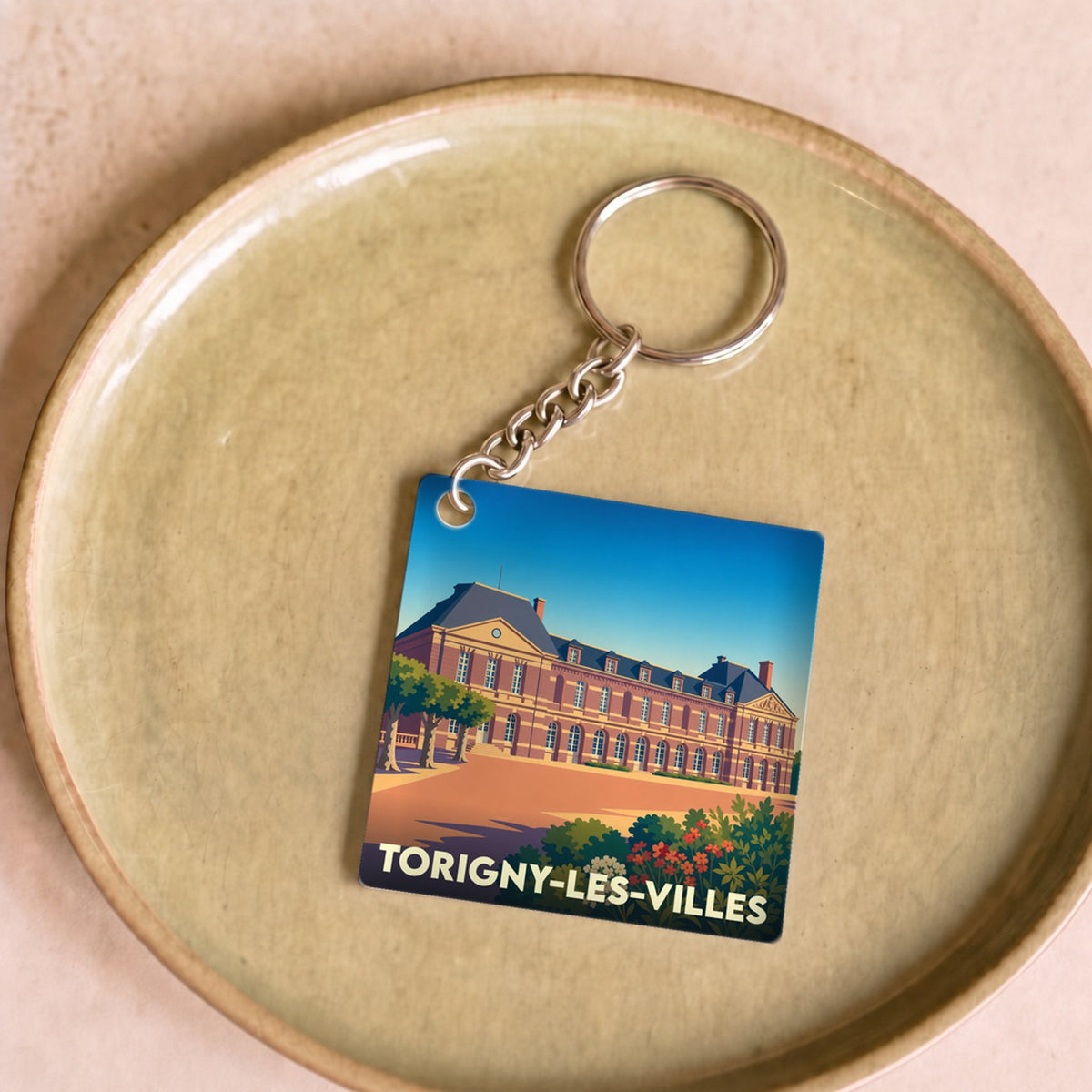 Porte-clés souvenir de la ville de Torigny-les-Villes avec une illustration stylisée de son château.