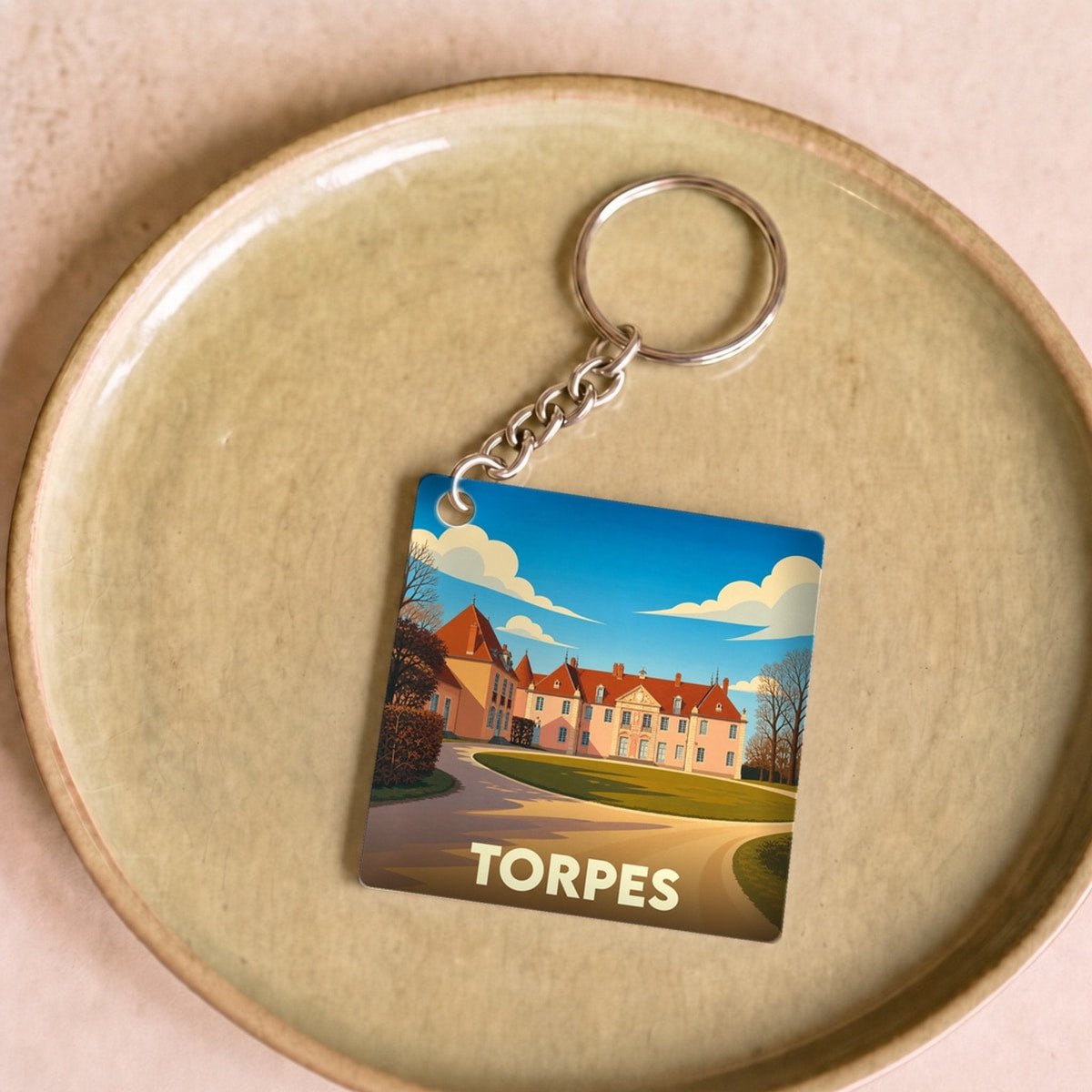 Porte-clés souvenir de la ville de Torpes avec une illustration stylisée de son château.