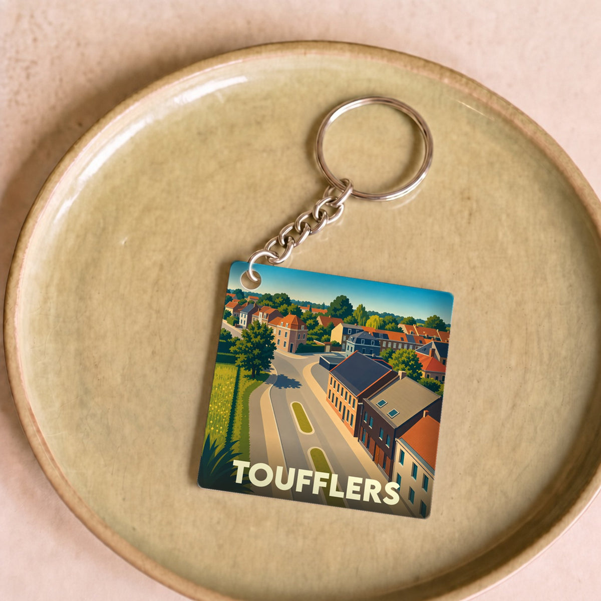 Porte-clés souvenir de la ville de Toufflers avec une illustration stylisée.