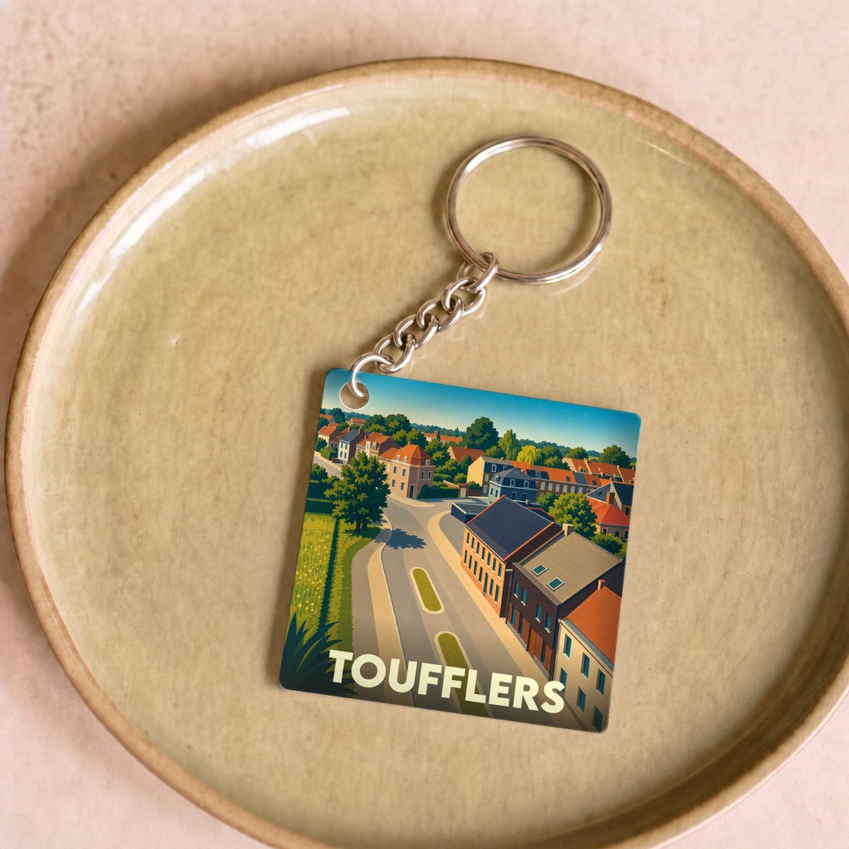 Porte-clés souvenir de la ville de Toufflers avec une illustration stylisée.