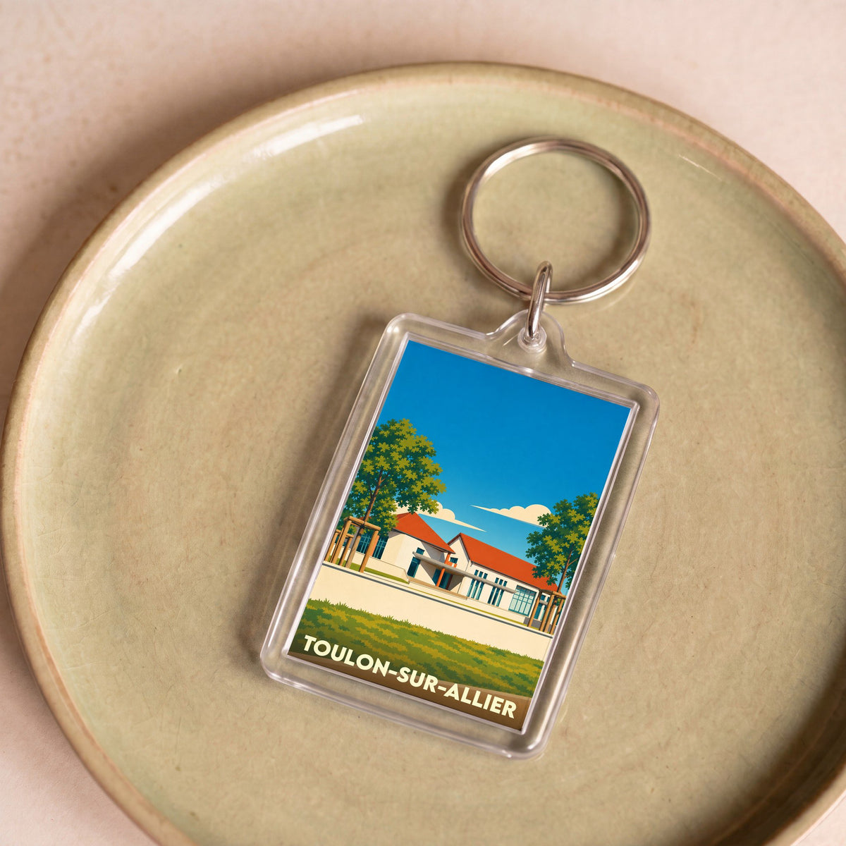 Porte-clés souvenir de la ville de Toulon-sur-Allier avec une illustration stylisée.