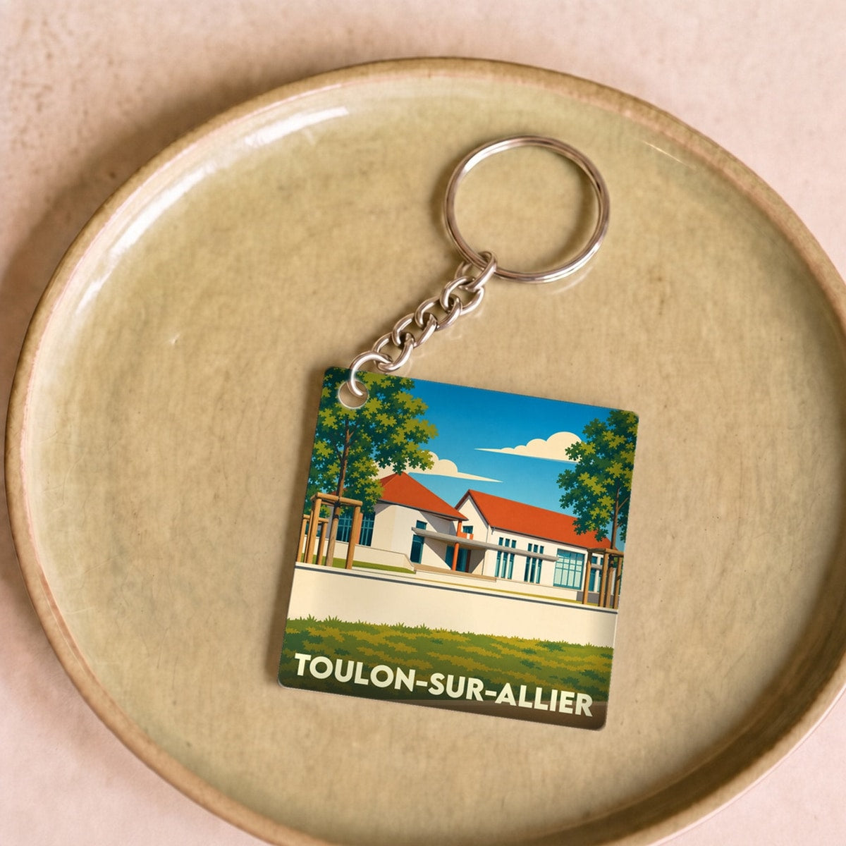 Porte-clés souvenir de la ville de Toulon-sur-Allier avec une illustration stylisée.