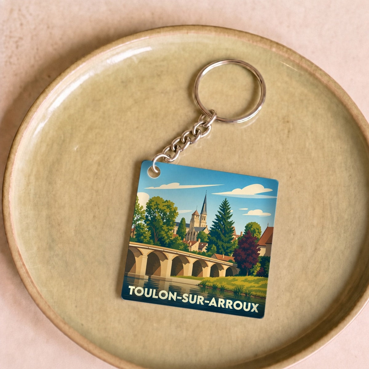 Porte-clés souvenir de la ville de Toulon-sur-Arroux avec une illustration stylisée.