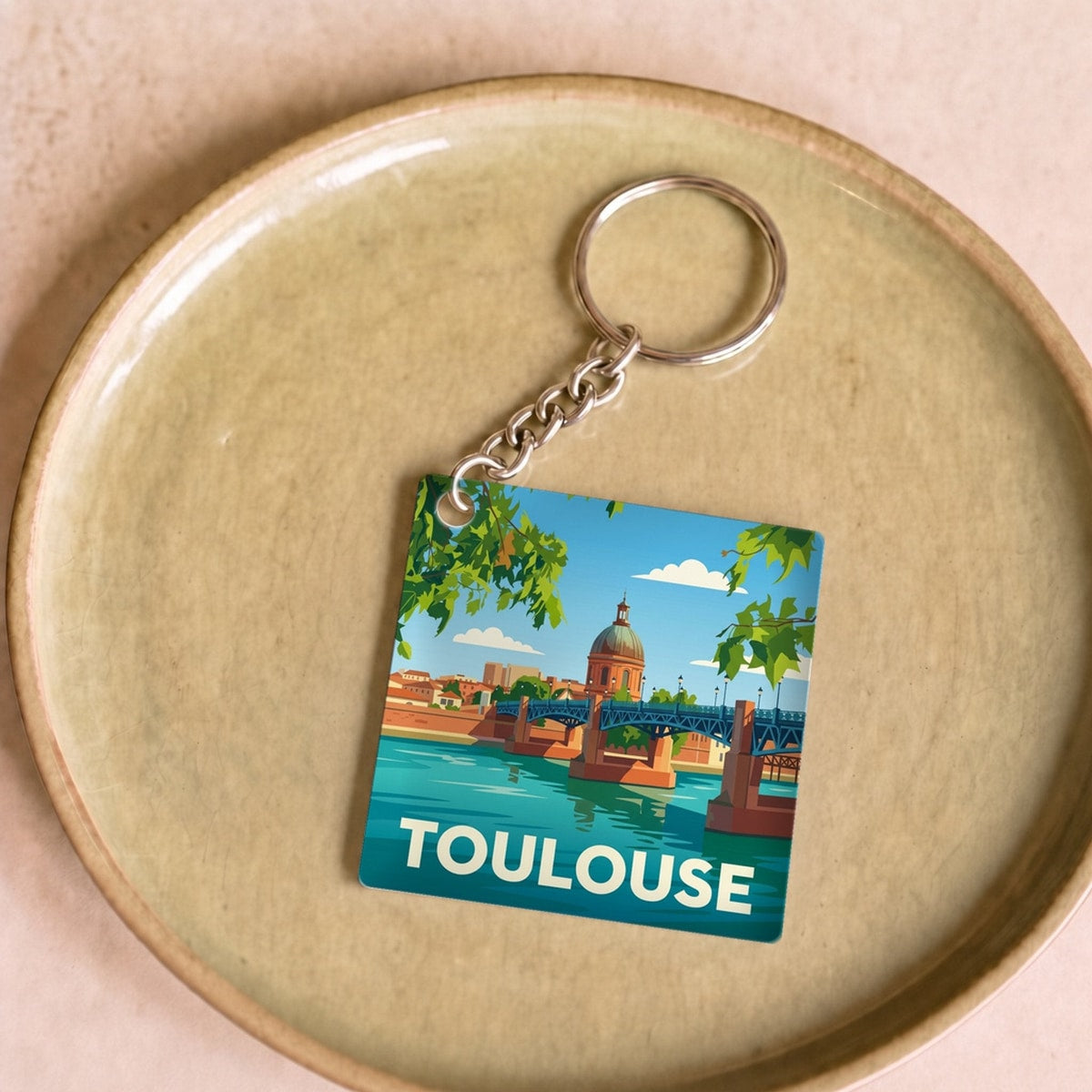 Porte-clés souvenir de la ville de Toulouse avec une illustration stylisée.